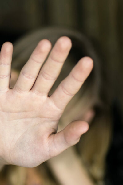A hand gesture signifying a stop. The girl's palm extended forward.